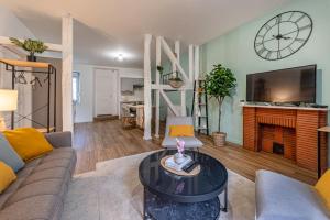 レンヌにあるLe Nid du Graverandのソファとテーブルのあるリビングルーム +2枚の写真