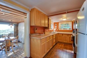 a kitchen with wooden cabinets and a dining room with a table at Mountain Cottage with Views Near Tail of the Dragon! in Fontana Village