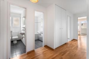 a white bathroom with a toilet and a sink at EXQUIS Design 3-Room Apartment KNOLL I Zurich Lake View I Balcony I Family-Friendly in Männedorf