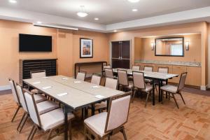 a conference room with tables and chairs and a television at Eastgate Hotel - BW Signature Collection in Bellevue