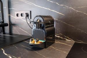 a coffee maker on a counter with two pairs of shoes at Saga - Cinema Room - By Primo in Chagny