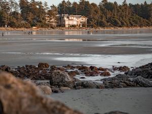托菲诺长滩度假旅舍的一片岩石海滩和一座房子