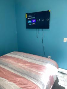 a bedroom with a bed and a tv on the wall at Peace Haven Stay in Newark
