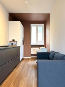 サロンノにあるCasa Lucrezia - Boutique Apartment Saronno - 3Dame Collectionの青いソファとキッチンのあるリビングルーム +7枚の写真