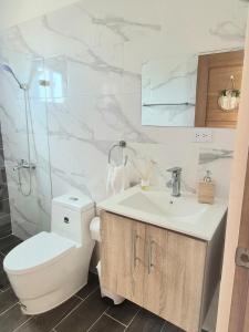 a bathroom with a toilet and a sink at Villa Mar in Punta Cana