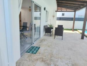 a patio with glass doors and chairs and a table at Villa Mar in Punta Cana