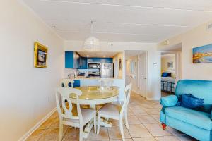 une cuisine et une salle à manger avec une table et un canapé bleu dans l'établissement Excalibur 905, à Ocean City 9 autres photos