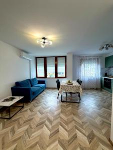 Una sala de estar con un sofá azul y una mesa. en Apartament Draganovi 8, en Kazanlak