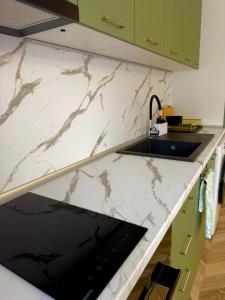 cocina con encimera de mármol y fregadero en Apartament Draganovi 8, en Kazanlak