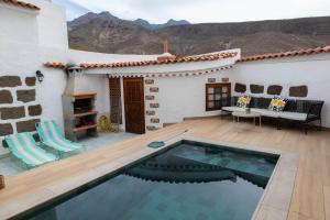 a house with a swimming pool and a patio at Casa Mari in Agaete