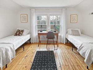 a room with two beds and a desk and a window at Relaxing 6 -bedroom Escape Near Ingersoll Avenue in Des Moines