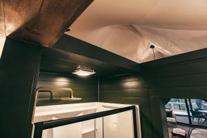 a bathroom with green walls and a sink and a mirror at Luxury Glamping Tent - The Perch - Near Tryon Equestrain Center in Mill Spring