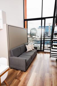 ein Sofa im Wohnzimmer mit einem großen Fenster in der Unterkunft 305 apartamento lof taj 97 cerca al parque 93 in Bogotá