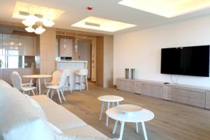 a living room with tables and a flat screen tv at Cosmo Apartments Platja d'Aro in Platja d'Aro