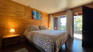 a bedroom with a bed with a wooden wall at Verdevida Apart Hotel in Pucón
