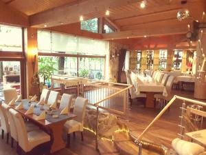 a restaurant with white chairs and tables and windows at Hotel Gasthaus Papen Änne in Kassel