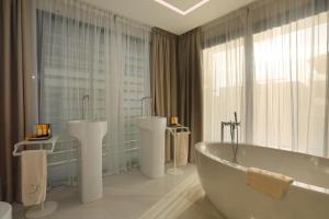 ein weißes Bad mit einer Badewanne und 2 Waschbecken in der Unterkunft Cosmo Apartments Platja d'Aro in Platja  d'Aro