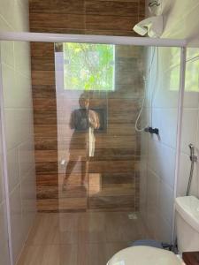 a person taking a picture in a shower in a bathroom at Recanto do Bosque in Majé