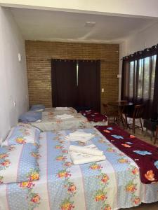 a group of beds in a room with towels on them at Recanto do Bosque in Majé