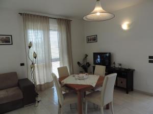 sala de estar con mesa de comedor y sillas en Villa Boemia - apartment, en Coriano