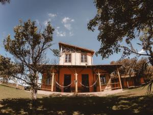 a house with a tree in front of it at Pousada Mãe Terra in Torrinha
