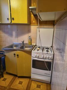 a kitchen with a stove and a sink at Pleasant apartament im center low price in Konin