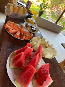 einen Tisch mit zwei Tafeln Wassermelone und anderen Früchten in der Unterkunft Chalés Pouso da Coruja - Vista para piscina in Cavalcante