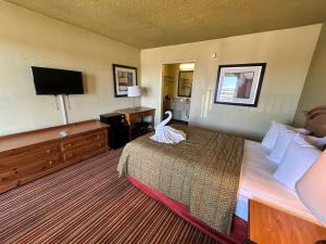 a hotel room with a bed with a swan on it at Suite Dreams Motel By Capital O Mattoon I - 57 in Mattoon
