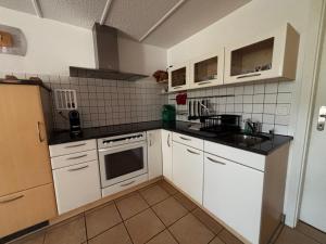 a small kitchen with white cabinets and a sink at Chalet Murmeli in Eigenthal +24 photos