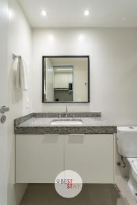 a bathroom with a sink and a mirror at Charmosos Apartamentos Reformados na Glória in Rio de Janeiro