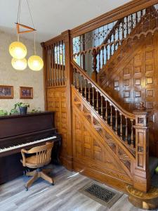 a wooden staircase with a piano in a room at Second Floor Apartment in Victorian House in Strathroy +3 photos