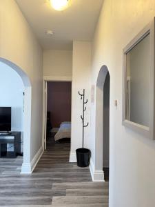 a hallway with a living room with a tv at Second Floor Apartment in Victorian House in Strathroy
