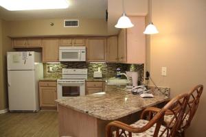a kitchen with a white refrigerator and a counter at Pelican Pointe 1106 in Romar Beach