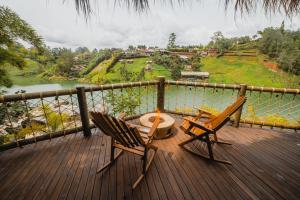 two chairs and a table on a deck overlooking a river at Atma Villas Hotel Boutique Guatapé in Guatapé