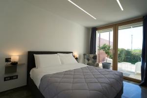 CasalecchioにあるRimini, 4 Camere con Giardino Privato e Parcheggio Gratuito, Relax a 10 Minuti dal Mareの大きなベッドと大きな窓のある寝室 +69枚の写真