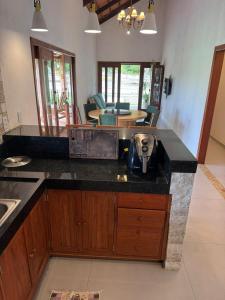 a kitchen with a counter top and a living room at Casa Verde Jade in Areia
