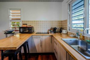 a kitchen with a wooden counter top with a microwave at Fare Mihiau Moorea in Irioa