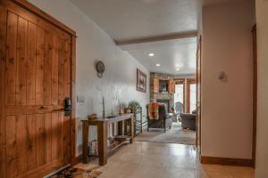 a hallway with a wooden door and a living room at Antlers Gulch 501 by SummitCove Lodging in Keystone