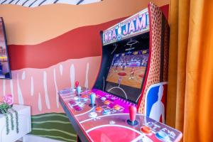 une console de jeux vidéo dans une pièce avec un terrain de basket dans l'établissement Movie Theater and Mini Golf with 2 King Beds, à Broomfield