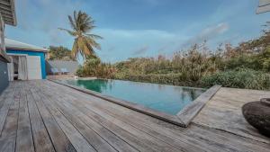 a wooden deck with a swimming pool on a house at Villa zen in Saint-François