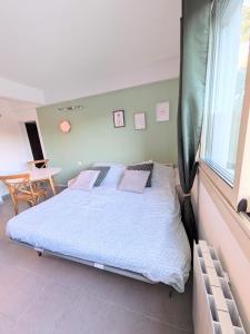 a bedroom with a bed and a table and a window at Emplacement idéal à 150 m des thermes T2 Gorges du Verdon in Gréoux-les-Bains +7 photos