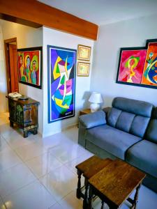 ein Wohnzimmer mit einem Sofa und Gemälden an den Wänden in der Unterkunft Playa del Arenal Avenida Paris 8 in Platja de l'Arenal