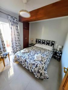 ein Schlafzimmer mit einem Bett mit einer schwarz-weißen Bettdecke in der Unterkunft Playa del Arenal Avenida Paris 8 in Platja de l'Arenal