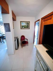 ein Wohnzimmer mit einem Flachbild-TV und einem Stuhl in der Unterkunft Playa del Arenal Avenida Paris 8 in Platja de l'Arenal + 17 Fotos