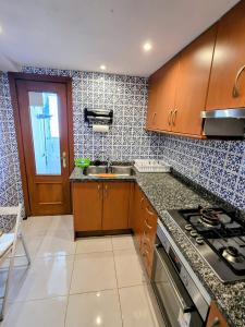 eine Küche mit Spüle und Herd oberen Backofen in der Unterkunft Playa del Arenal Avenida Paris 8 in Platja de l'Arenal