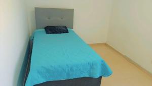 a small bedroom with a blue bed in a room at Departamento con cochera - Condominio Las Flores in Ica