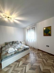 a bedroom with a bed and a wooden floor at Apartment Draganovi 8A in Kazanlŭk