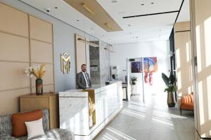 Un hombre de pie en un mostrador en un vestíbulo. en MH HOTEL Nouakchott, en Nouakchott