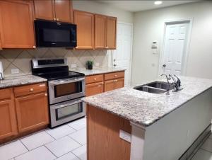 カイルにあるLovely Room 1 Near San Marcosatxのシンクとコンロのあるキッチン トップオーブン +22枚の写真