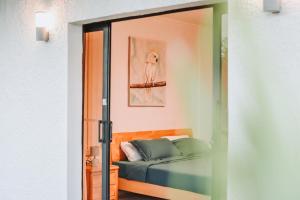 a bedroom with a bed and a glass door at The Coastal Charm in Grand-Baie
